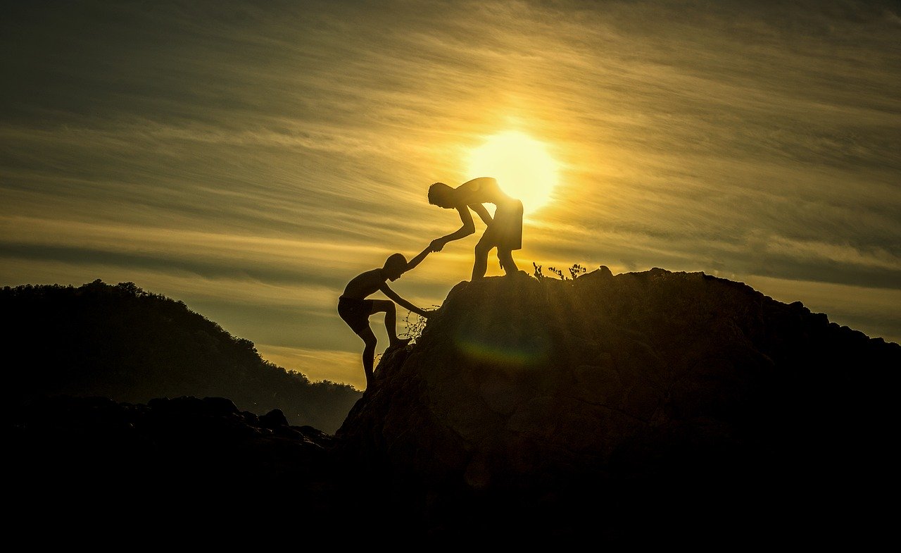 man help to climb up another boy